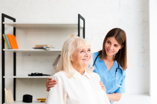 Nurse and old woman looking on the window