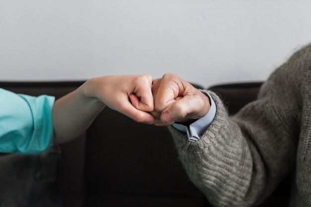 Nurse and older man fist bumping