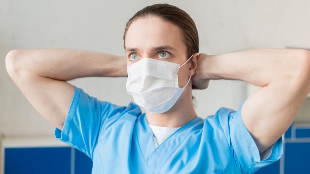 Медсестра надевает медицинскую маску
