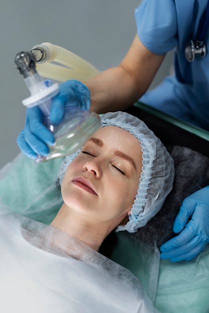 Foto gratuita infermiera che mette la maschera di ossigeno al paziente
