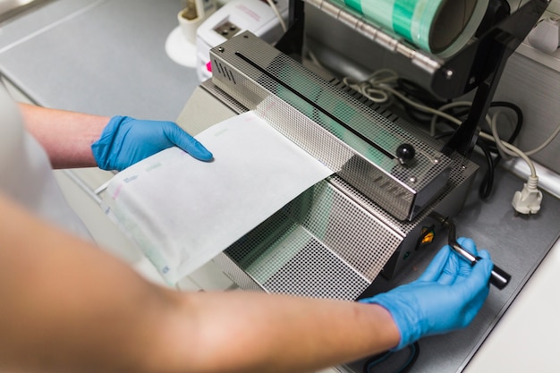 Nurse removing plastic from pouch sealer packaging machinery