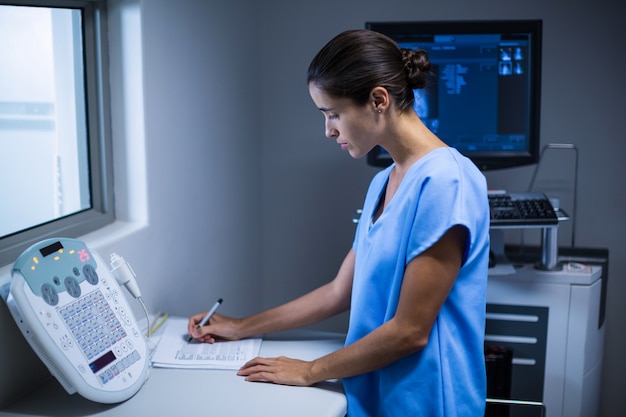 Nurse taking notes in x-ray room