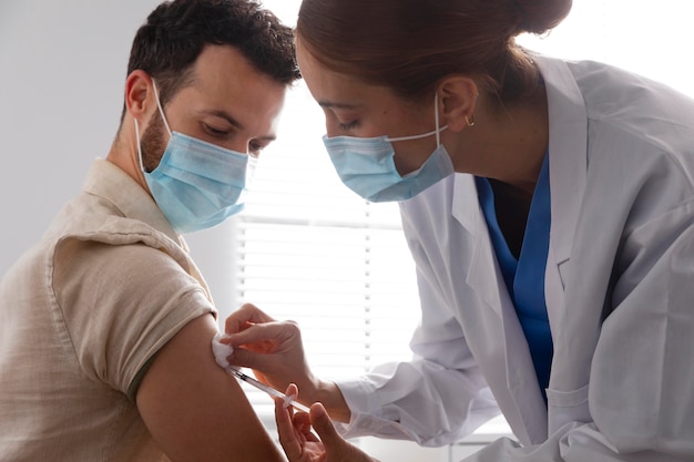 Nurse vaccinating a male patient