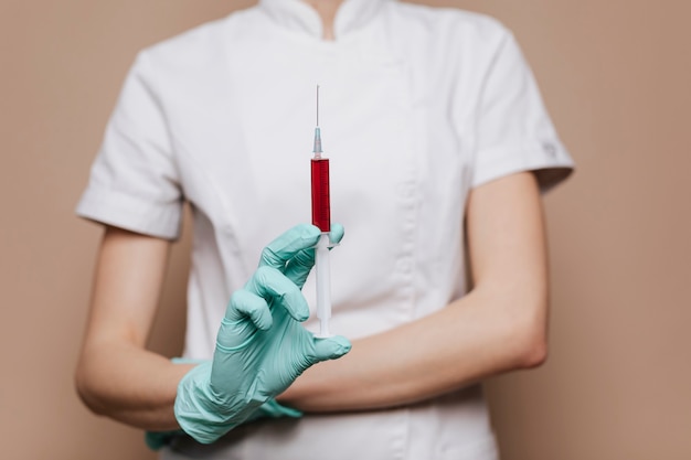 Free photo nurse with a syringe in her gloved hand