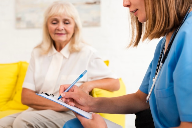 Nurse writing on clipboard close-up