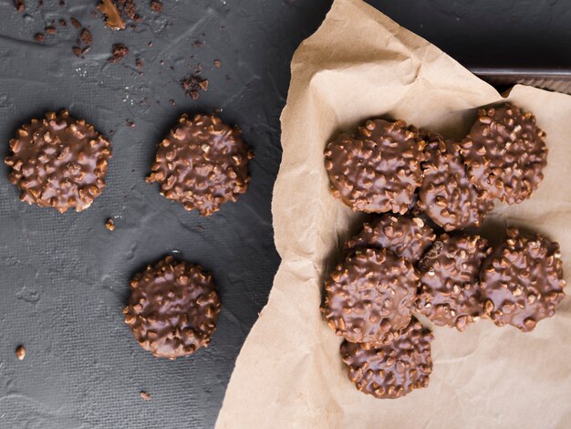 Nut biscuits covered with chocolate scattered on table