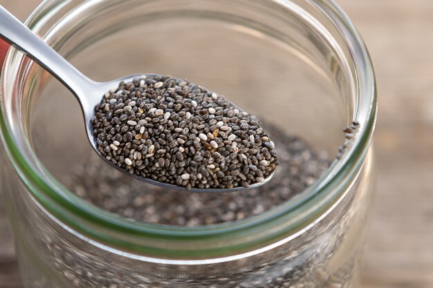 Nutritious chia seeds on a spoon, close up.