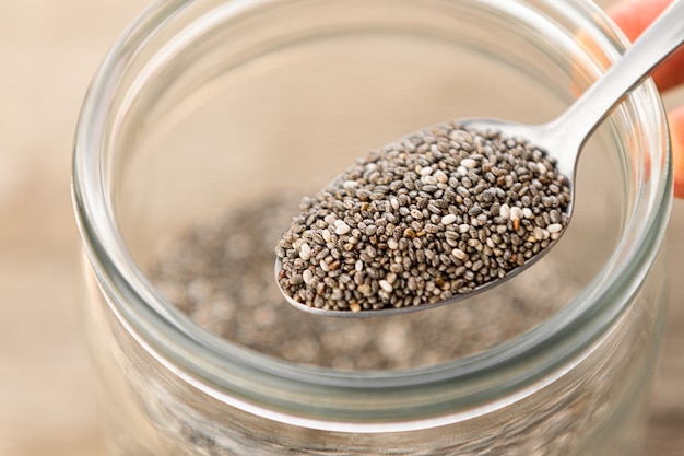Nutritious chia seeds on a spoon, close up.