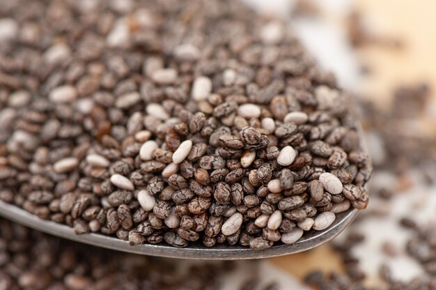 Nutritious chia seeds on a spoon, close up.