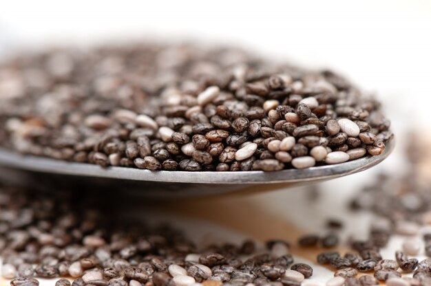 Nutritious chia seeds on a spoon, close up.