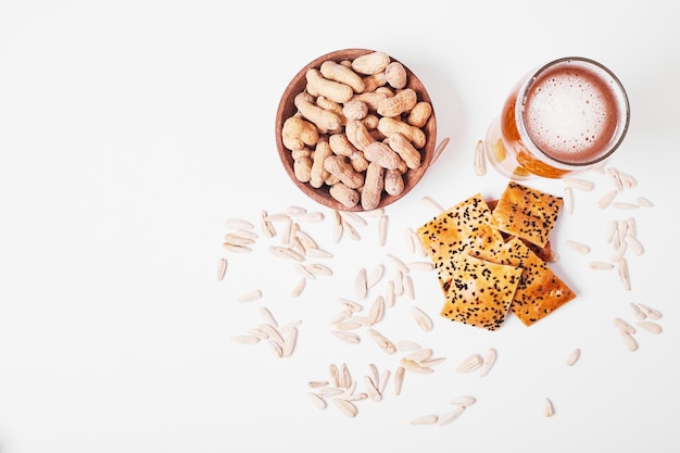 Nuts and crackers with beer on white.