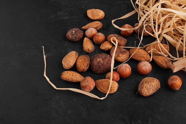 Nuts and dry fruits on black surface. 