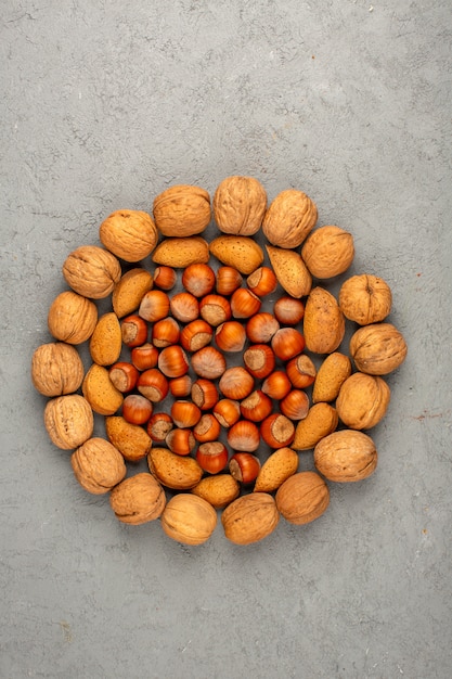 Гайки круглой формы различных орехов на сером полу