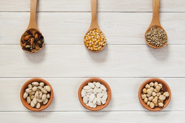 Nuts and seeds in spoons and bowls