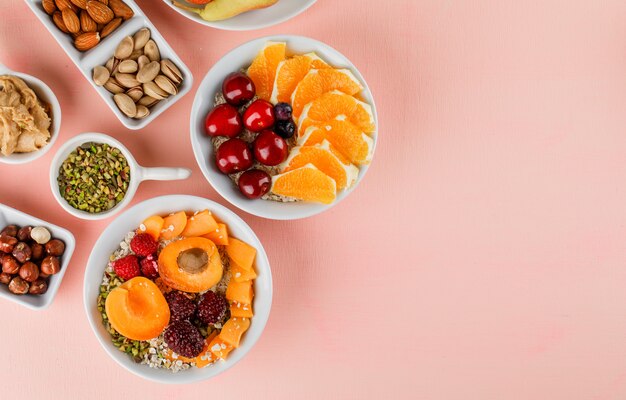 Oat flakes in bowls with fruits, nuts, peanut butter