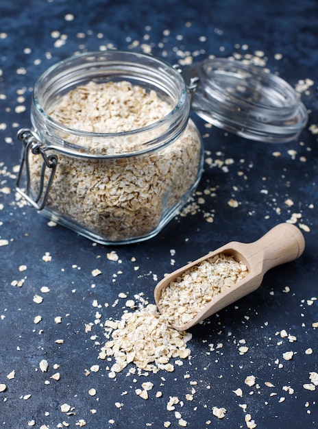 Free photo oat flakes in glass jar on dark background. top view. uncooked oatmeal