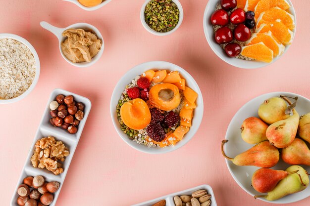 Oat flakes with fruits, nuts, peanut butter in bowls