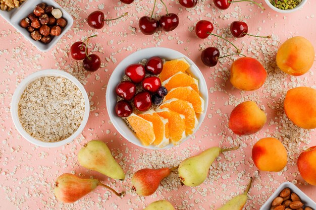 Oat flakes with pear, apricot, orange, cherry, nuts in bowls