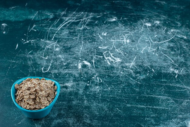 Oat granola in a bowl , on the blue background. High quality photo