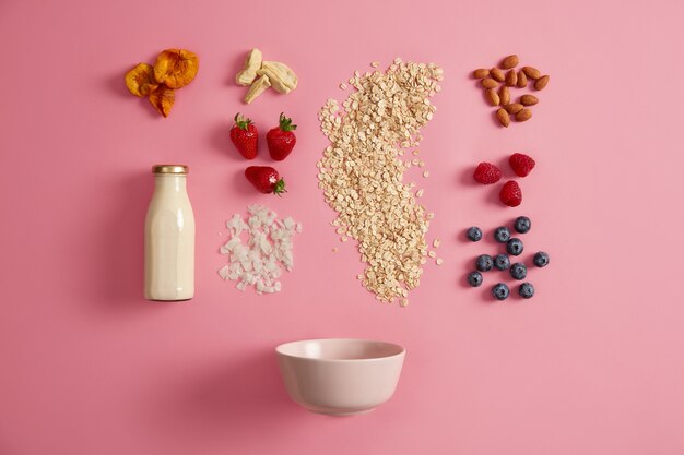 oatmeal cereals, appetizing fresh berries, dried fruits, vegetable milk, nuts and bowl to prepare tasty breakfast. nutrient porridge for your snack. ingredients for oatmeal. muesli preparation