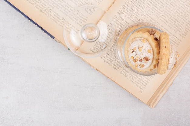 Oatmeal cookies in glass jar and on book.