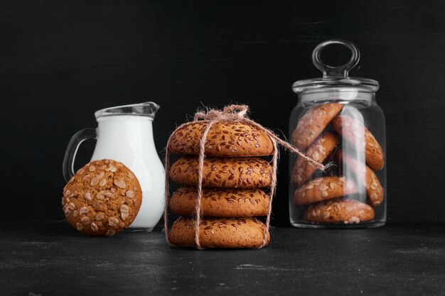 Oatmeal cookies with a jar of milk. 