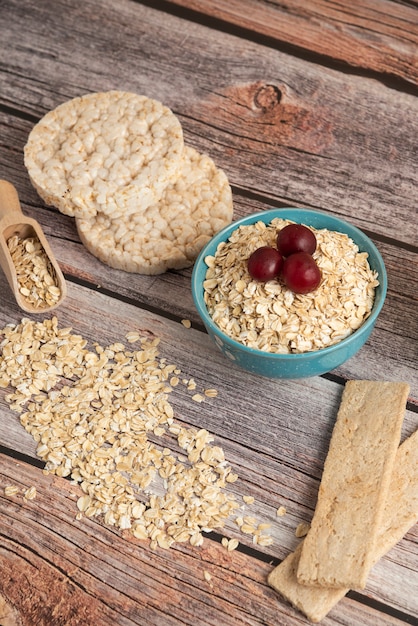 Foto gratuita cracker di farina d'avena, cereali con frutti di bosco e ciliegie sul tavolo