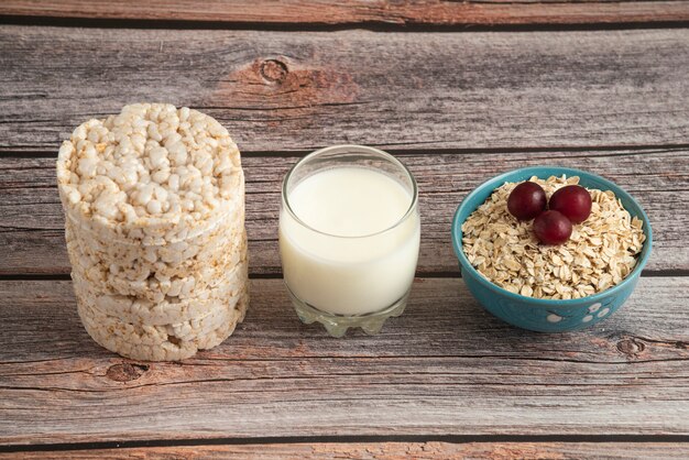 Oatmeal crackers, grains with berries and a cup of milk on the table