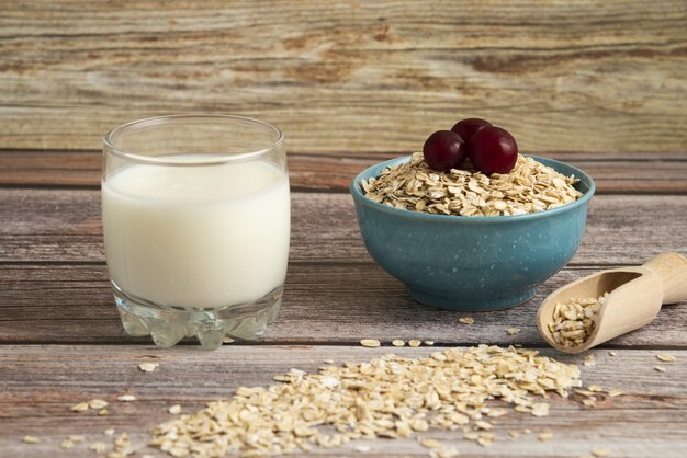 Oatmeal crackers, grains with berries and a cup of milk on the table