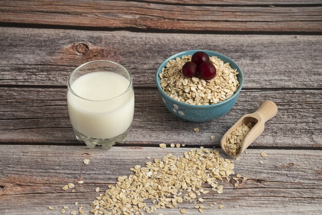 Oatmeal crackers, grains with berries and a cup of milk on the table