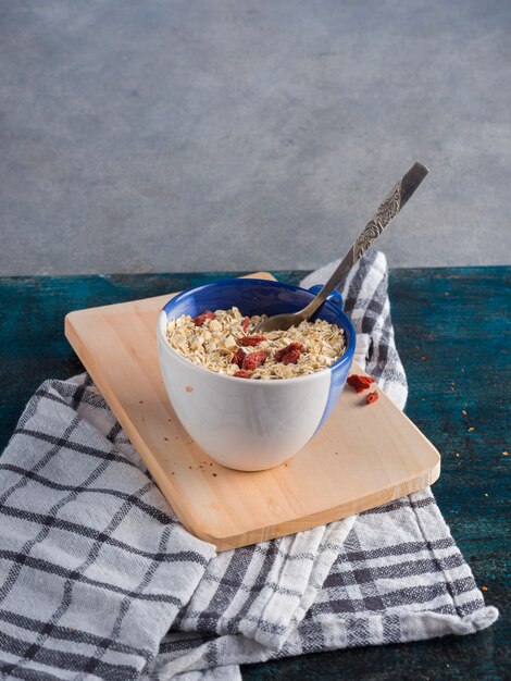 Oatmeal in cup on wooden board