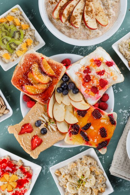 Oatmeal in plates with fruits, jam, nuts, cinnamon, fruit