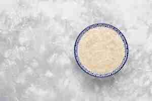 Free photo oatmeal porridge in a bowl on concrete ,top view