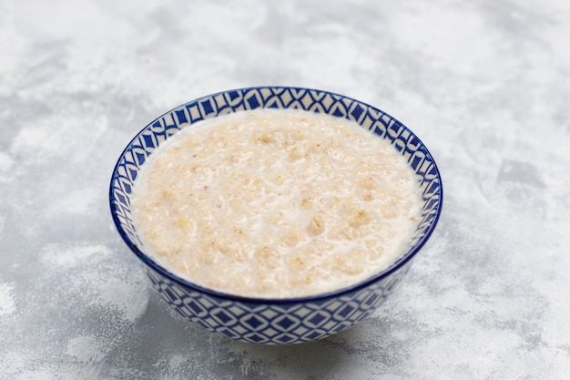 Oatmeal porridge in a bowl on concrete ,top view