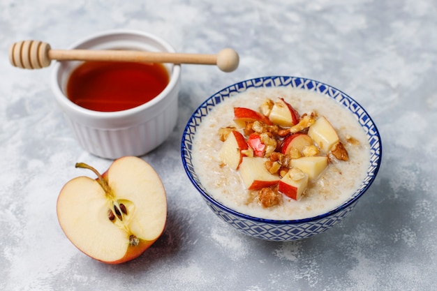 Porridge di farina d'avena in una ciotola con miele e fette di mela rossa, vista dall'alto