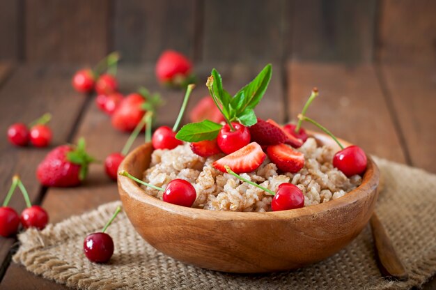 Oatmeal porridge with berries in a white bowl