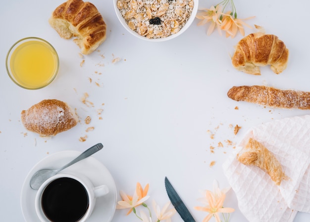 Oatmeal with croissants and coffee on table