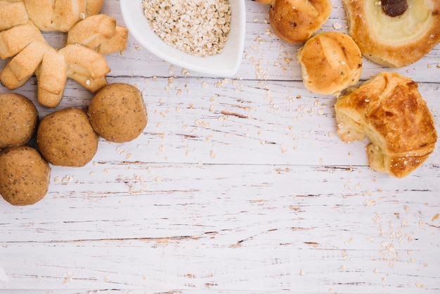 Oatmeal with different bakery on wooden table