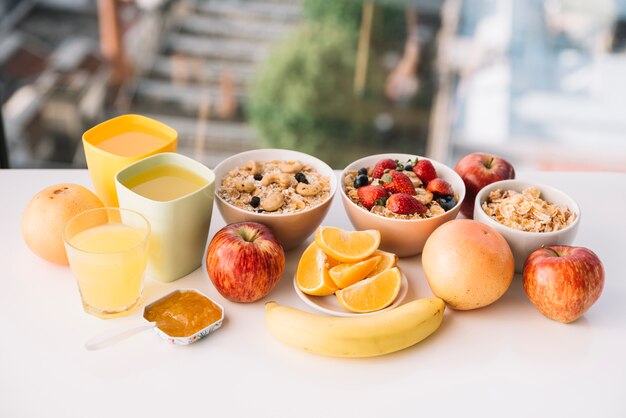 Oatmeal with fruits and juices on table