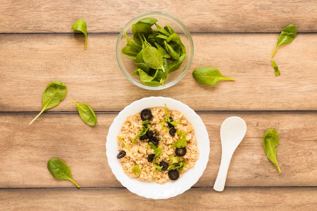 Oats garnished with basil leaf and olive for breakfast in bowl