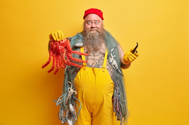 Бесплатное фото Полнобородый мужчина-матрос с рыболовной сетью