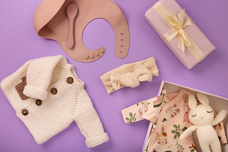 Ensemble cadeau naissance avec tricot, bavoir et pyjama floral, parfait pour évoquer les avantages des vêtements bébé fabriqués en Turquie dans un coffret prêt à offrir.