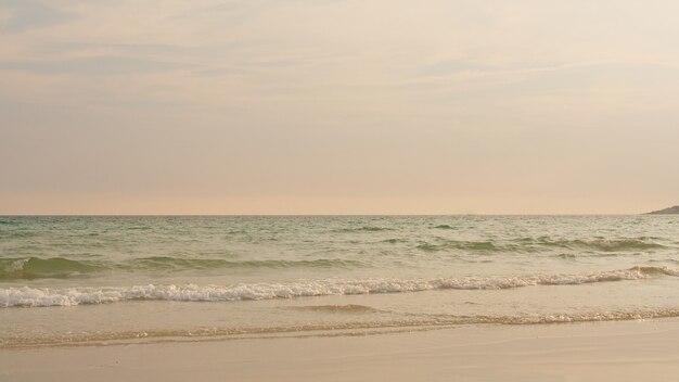 Ocean beach waves on tropical beach at sunset time