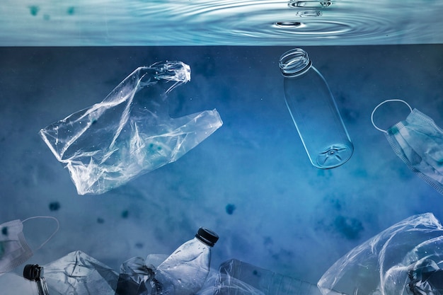 Free photo ocean pollution campaign with plastic bags and used bottles floating