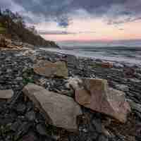 Free photo ocean waves crashing on shore during sunset