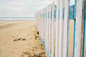 Free photo off-season rest. deserted spring beach, fence in front of a public beach, cloudy sky waiting for rain. off-season sea beach, place for text