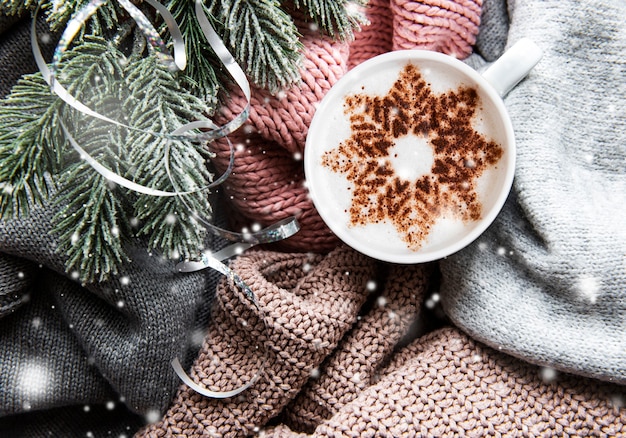Ð¡offee with a snowflake pattern on a warm knitted sweaters  surface
