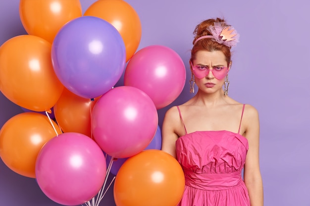 Offended displeased redhead woman looks angrily at camera