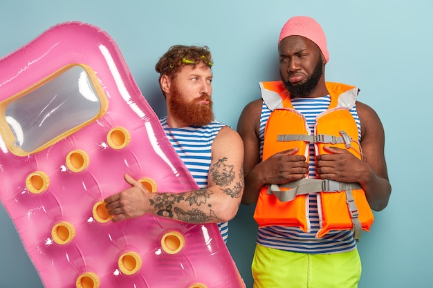 Offended dissatisfied friends posing with beach items