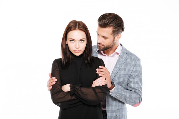 Offended young loving couple standing isolated